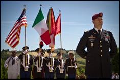 A group of people in military uniforms holding flags  Description automatically generated with low confidence